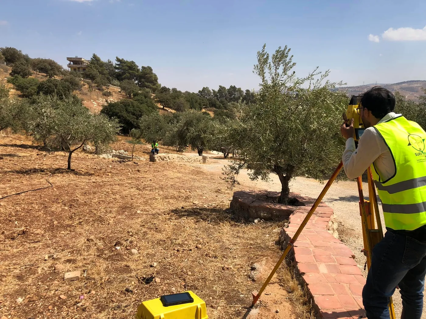 Surveyor operating a total station in a landscape